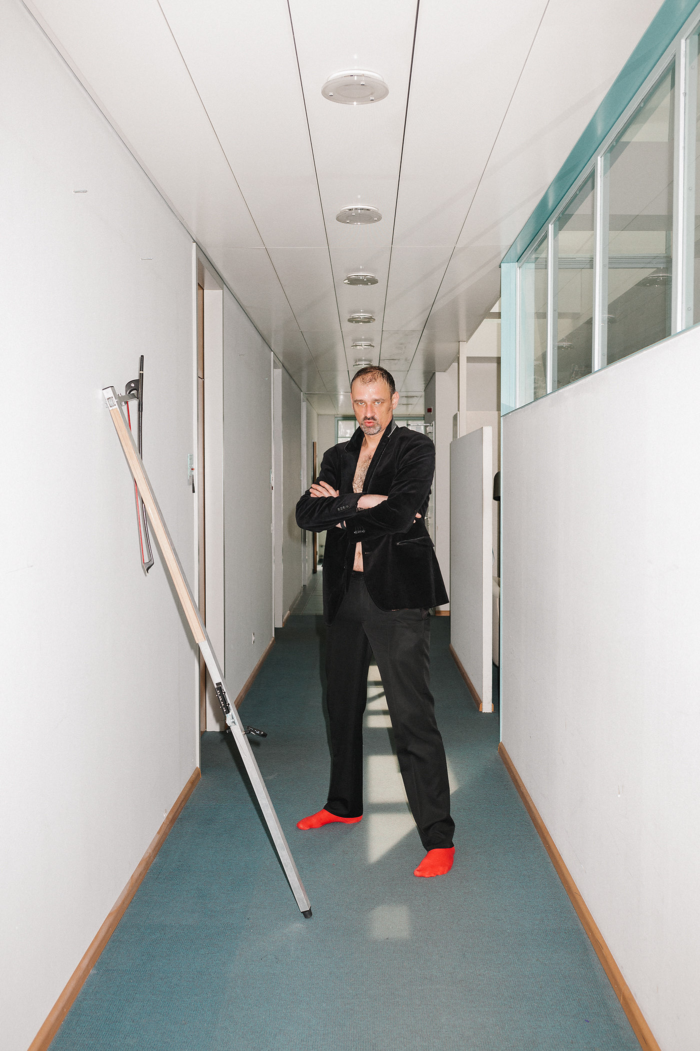 Aleksander Gabryś dans un couloir avec une échelle pendant le processus de portrait pour le Jahresbericht der Abteilung Kultur Basel-Stadt 2019.