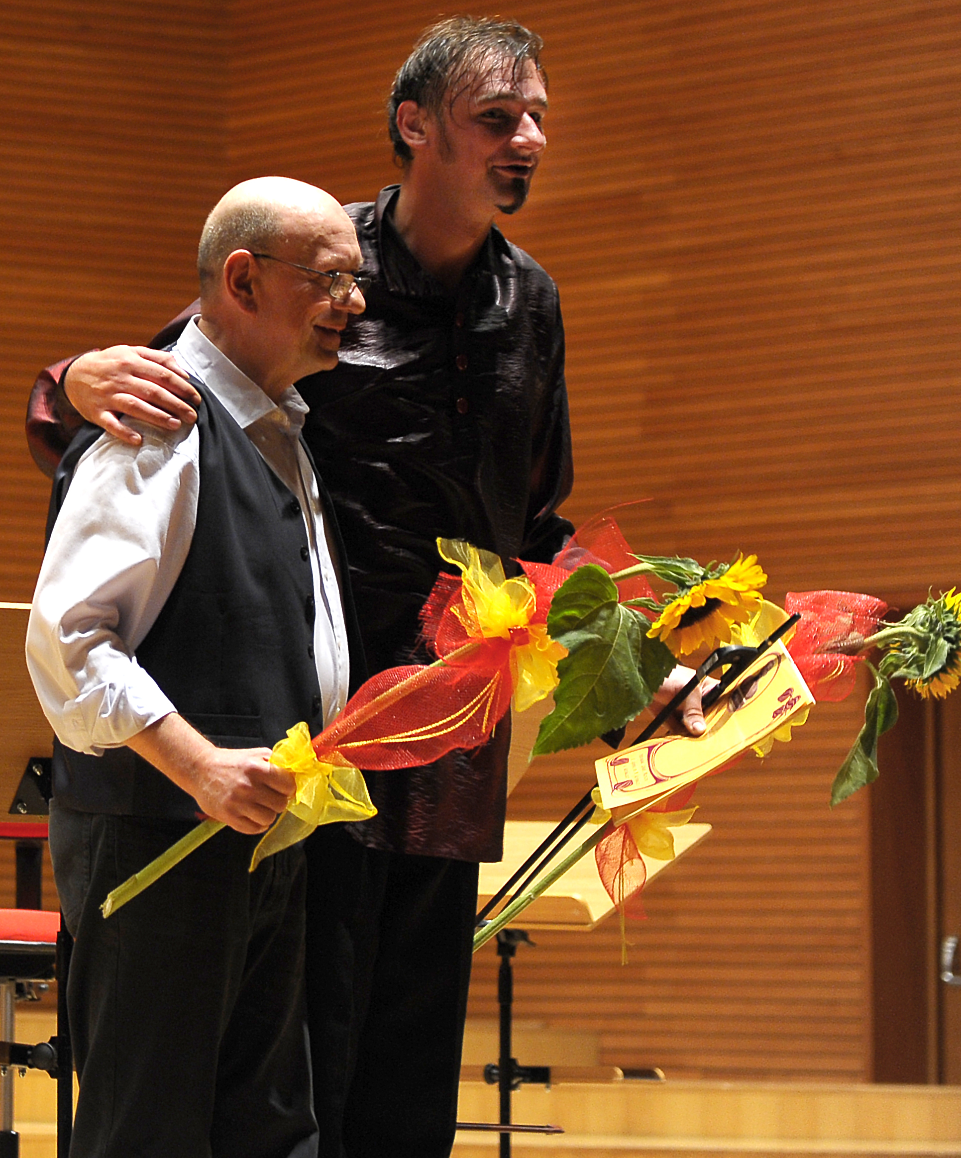 Zbigniew Wegehaupt and Aleksander Gabryś standing together with flowers after the concert.