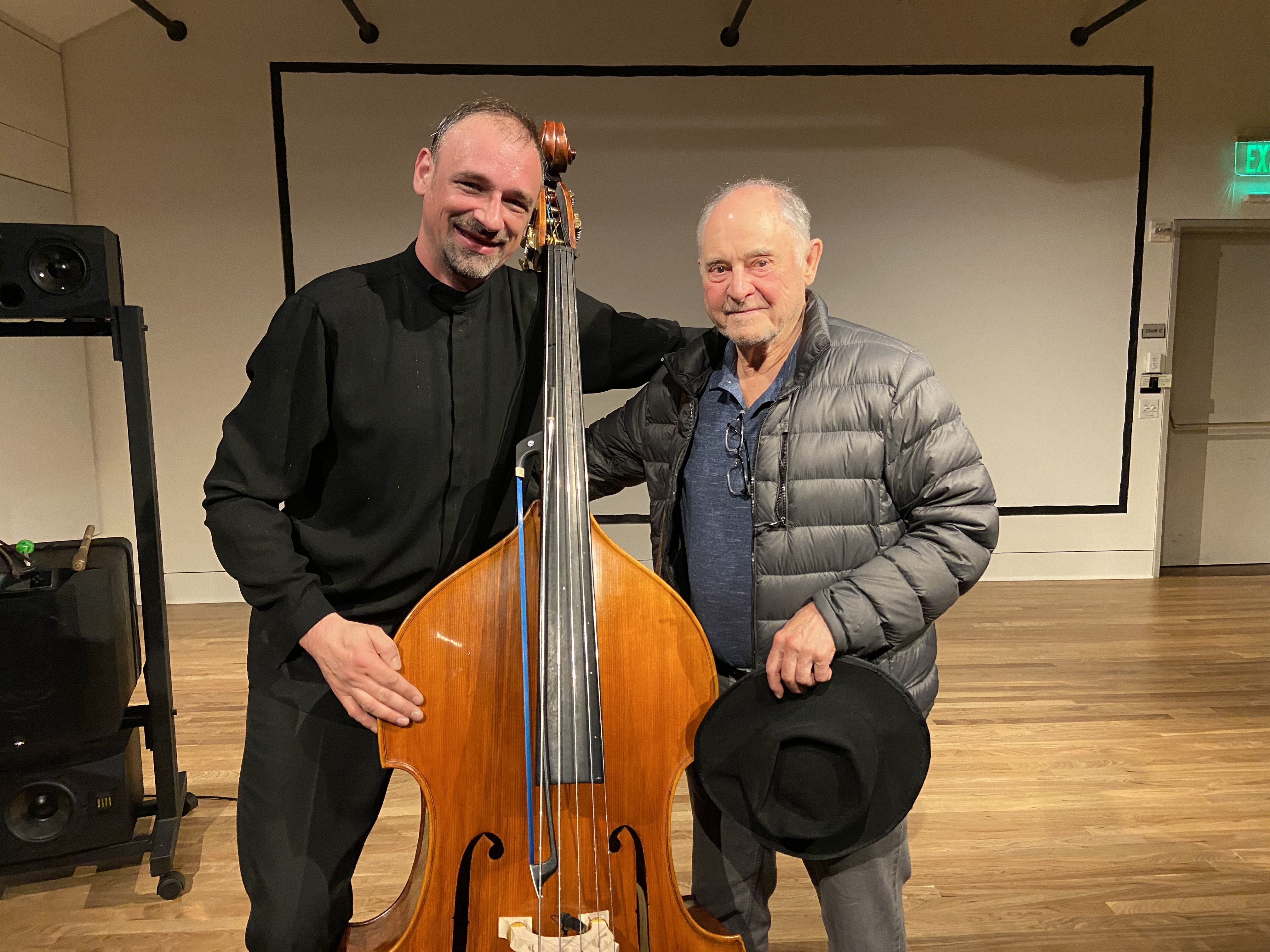 Aleksander Gabryś with John Chowning after a CCRMA recital, standing with a double bass.